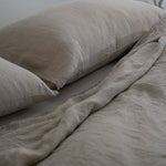 Sand bedding with pillows on a neutral background